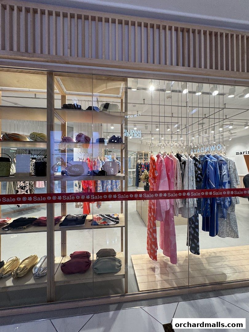 Marimekko Takashimaya shop window displaying clothing, bags, and accessories with a sale banner.