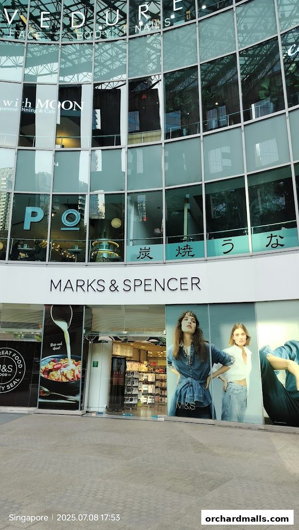 Exterior view of a Marks & Spencer store with large glass windows and signage.