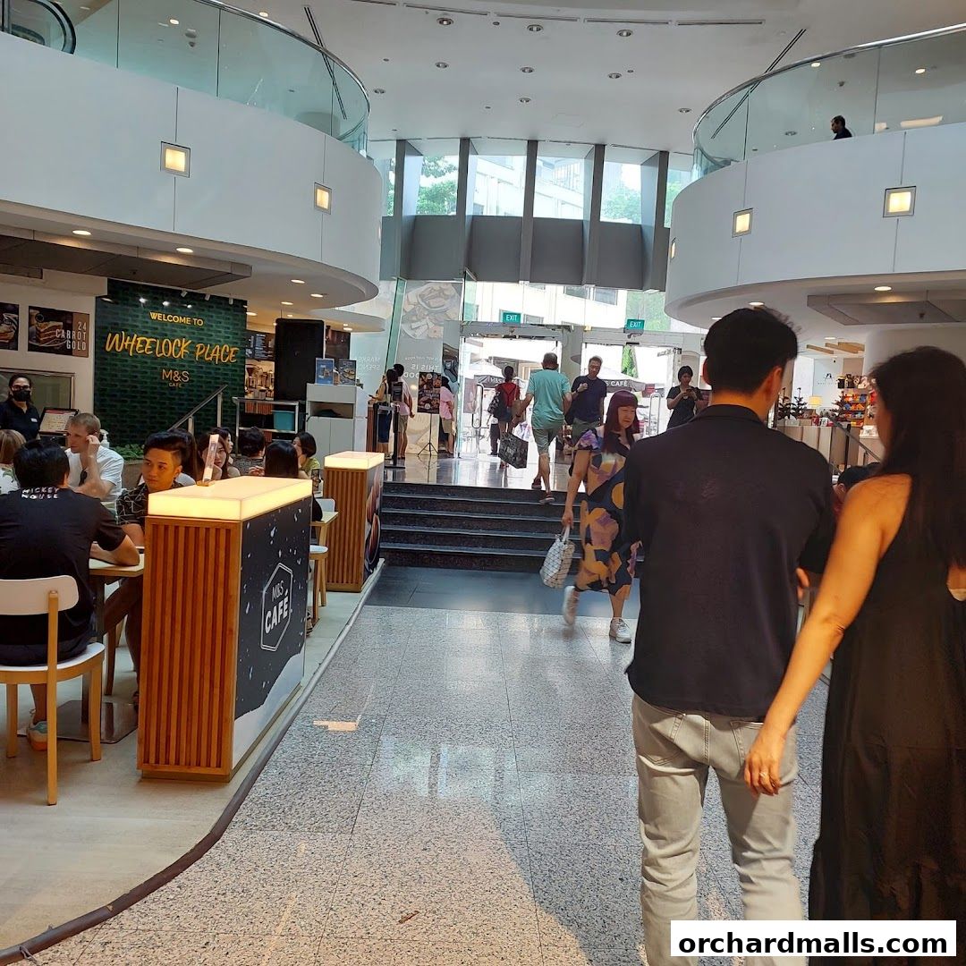 People walking inside a shopping mall near a Marks & Spencer cafe.