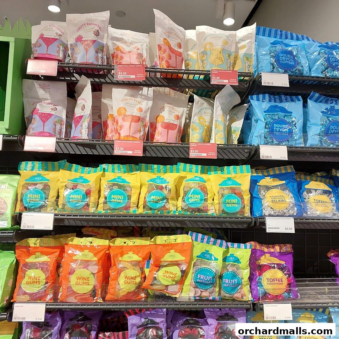 Shelves stocked with various bags of sweets and toffees from Marks & Spencer.