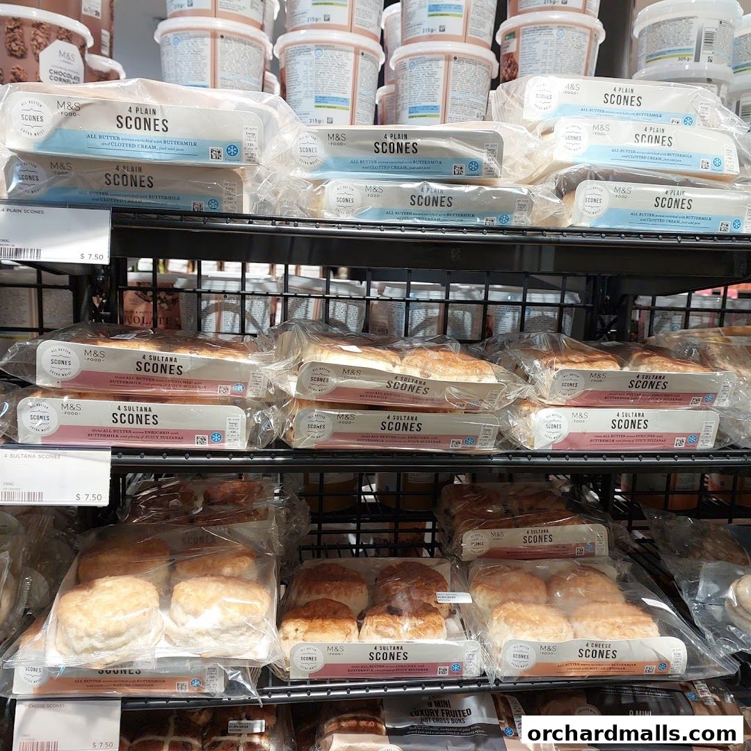 Shelves stocked with various types of M&S scones and hot cross buns.