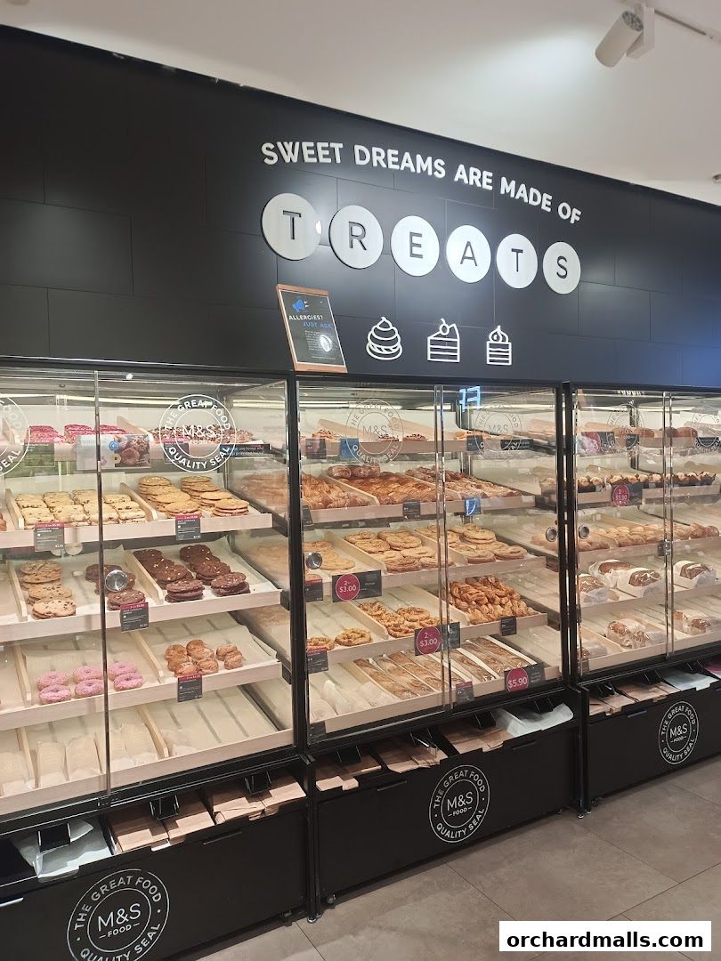 A display of various baked goods and treats at a Marks & Spencer food store.