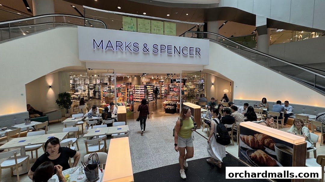 Marks & Spencer store entrance with a cafe area and shoppers inside.