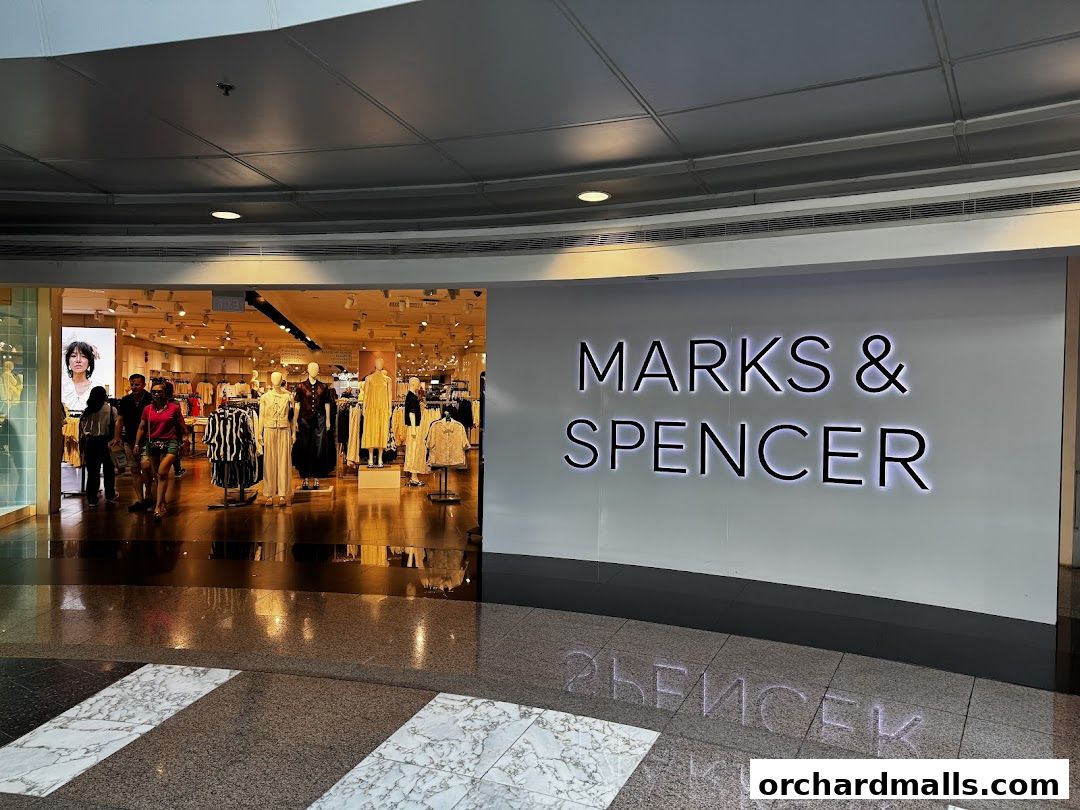 The entrance to a Marks & Spencer store, showcasing clothing displays and mannequins.