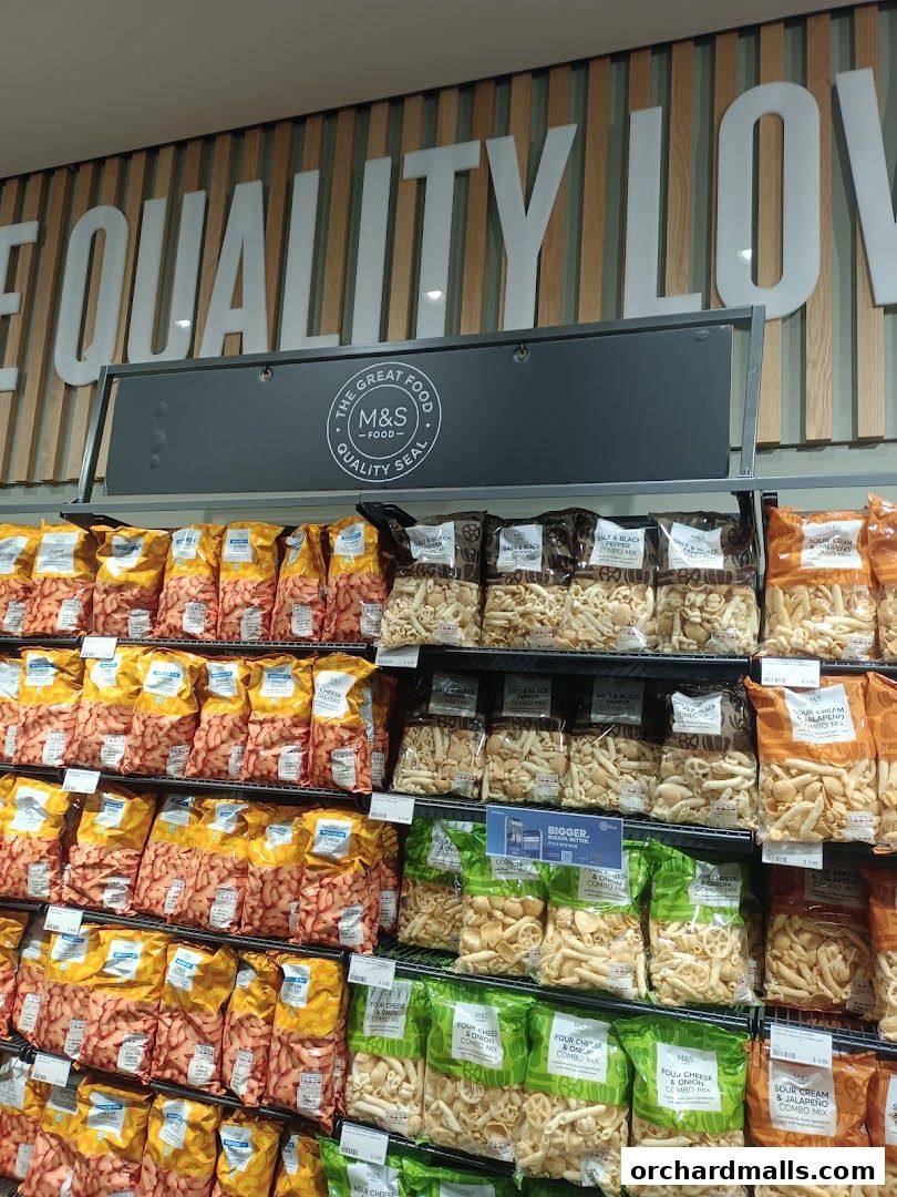 Shelves stocked with various bags of pasta and snacks at Marks & Spencer.
