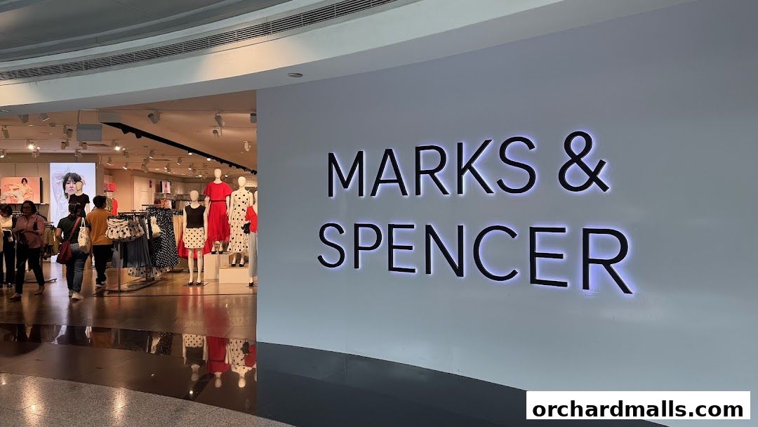 The illuminated "Marks & Spencer" logo is displayed prominently next to the shop's entrance.