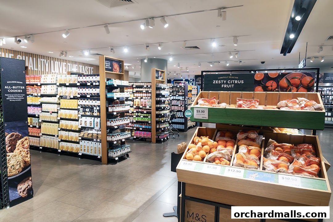 Interior view of a Marks & Spencer food section with shelves stocked with groceries and a fruit display.