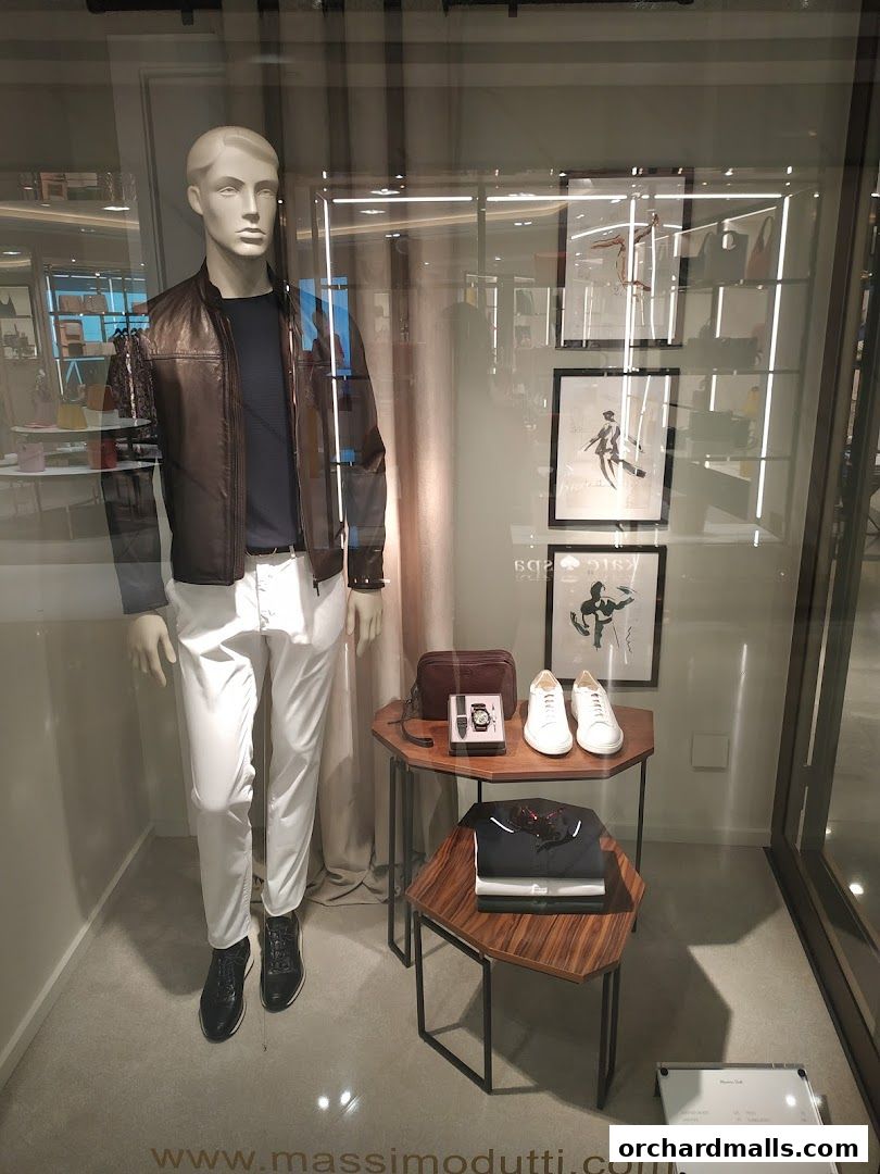 Mannequin in a Massimo Dutti store window display showcasing a leather jacket and white pants.