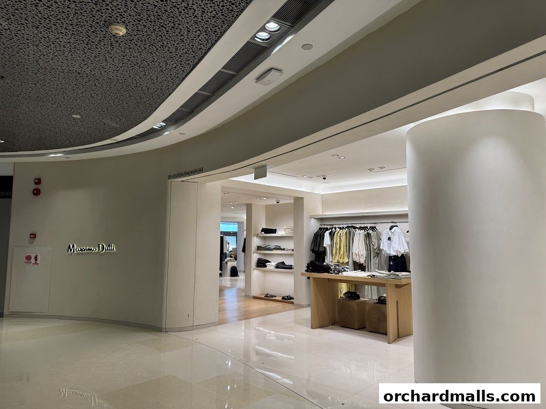 Interior view of a Massimo Dutti store with clothing displays and a prominent sign.