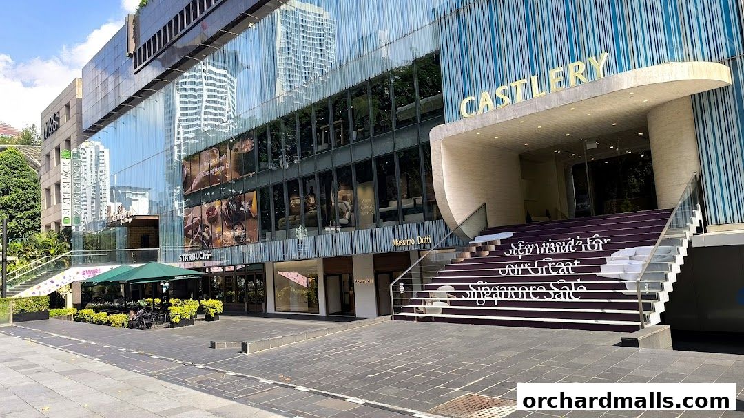 Exterior view of a modern building with multiple shops including Starbucks and Massimo Dutti.