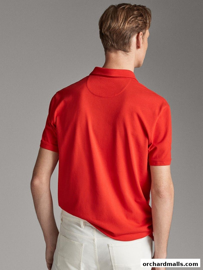 A man wearing a red polo shirt and white pants, viewed from the back.