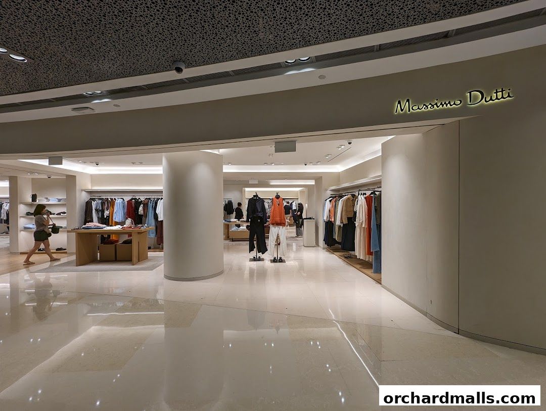 Interior view of a Massimo Dutti store showcasing clothing displays and a customer.