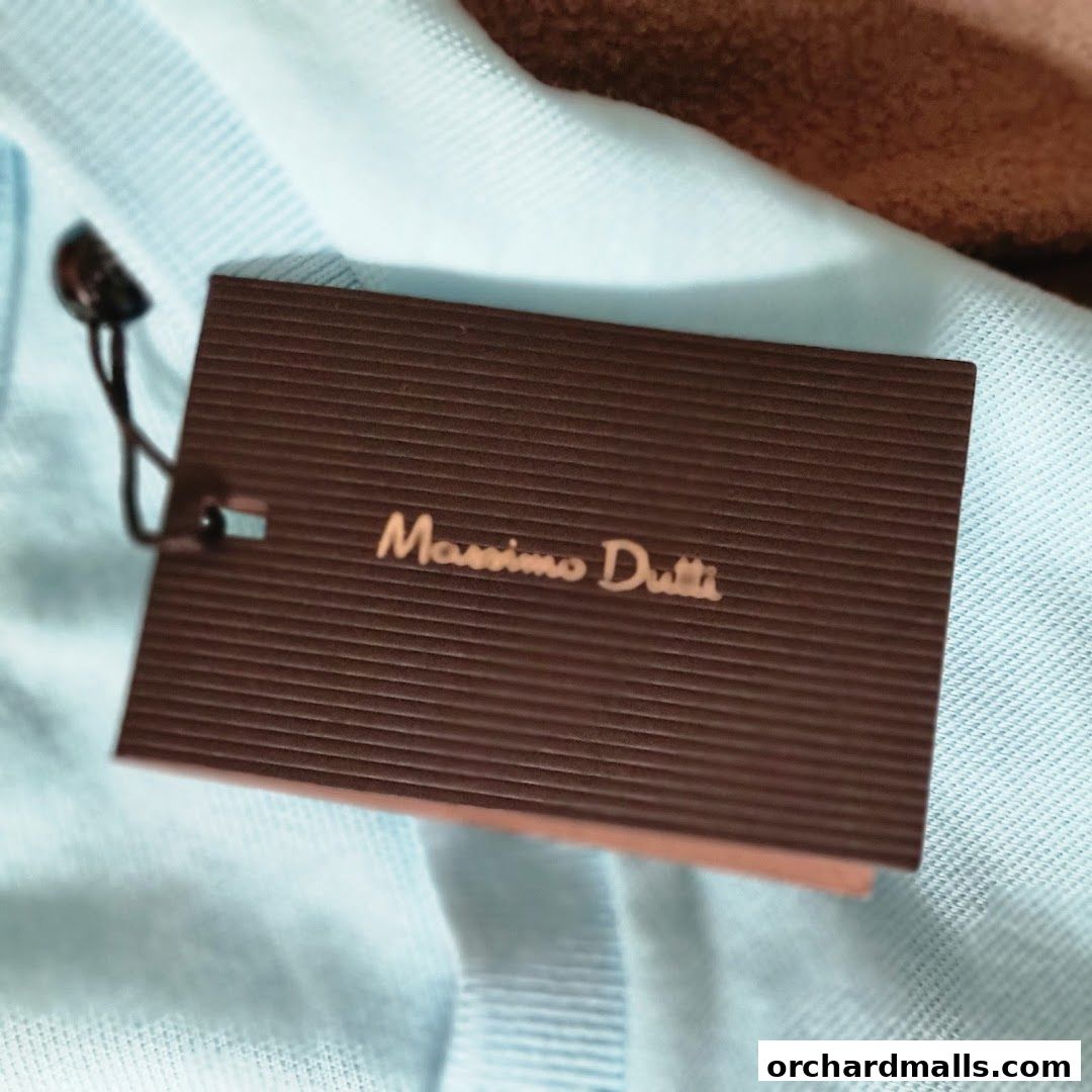 A close-up of a Massimo Dutti clothing tag attached to a light blue garment.