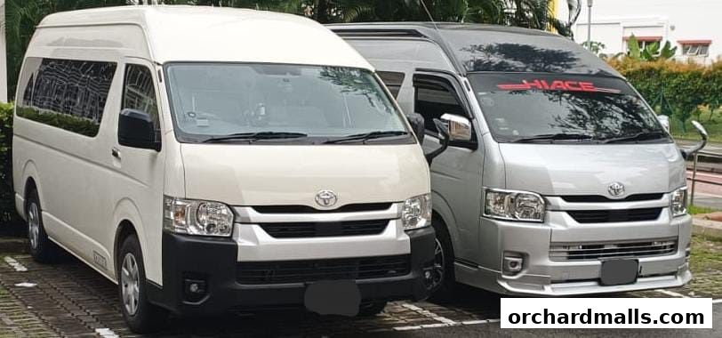Two Toyota Hiace vans, one white and one silver, parked side-by-side.