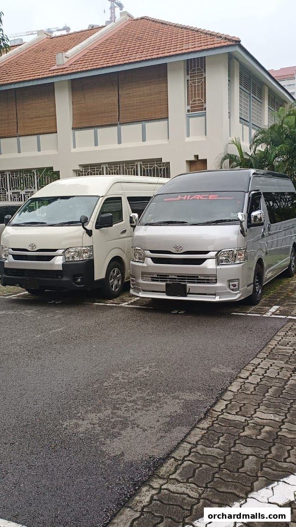 Two MaxiCabTransit vans parked in front of a building with tiled roof.