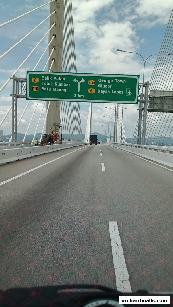A road sign on a bridge indicating directions to various locations and distances.