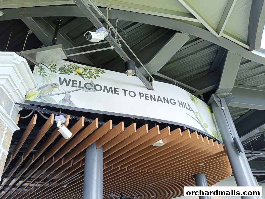 A sign welcomes visitors to Penang Hill with images of birds and foliage.