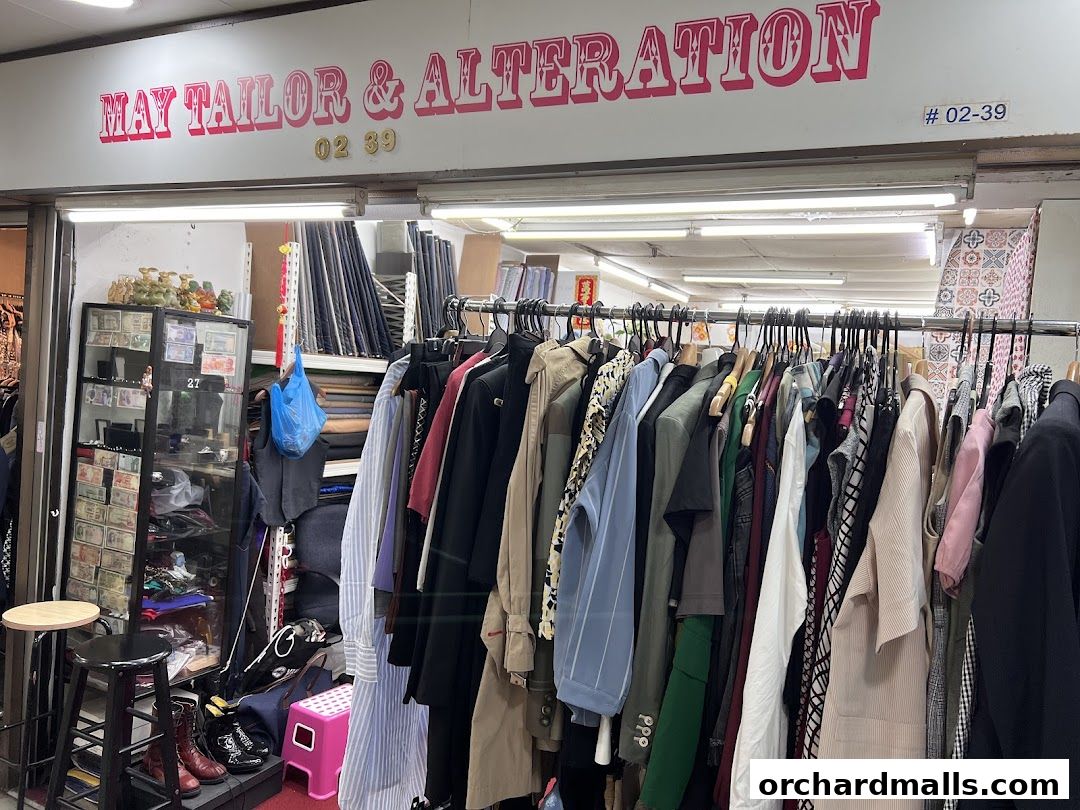 May Tailor & Alteration shop front with clothing racks and fabric displays.