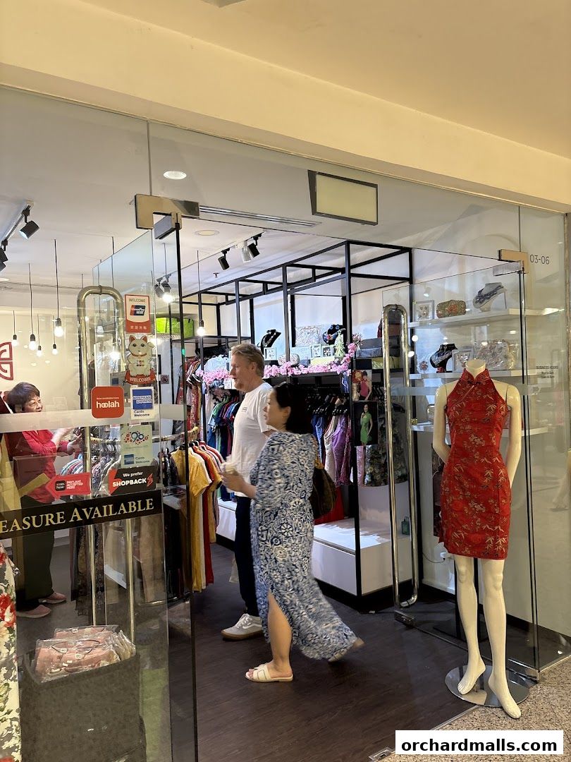 People browsing clothing inside a shop with mannequins displaying dresses.