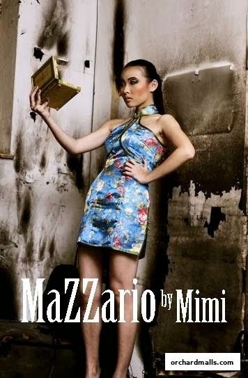 A woman in a floral dress holds a golden box against a textured background.