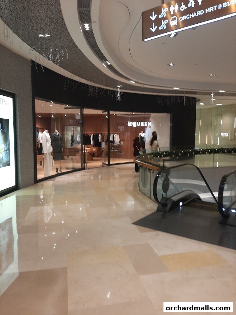 The McQueen shop front displays elegant fashion with mannequins showcasing outfits.
