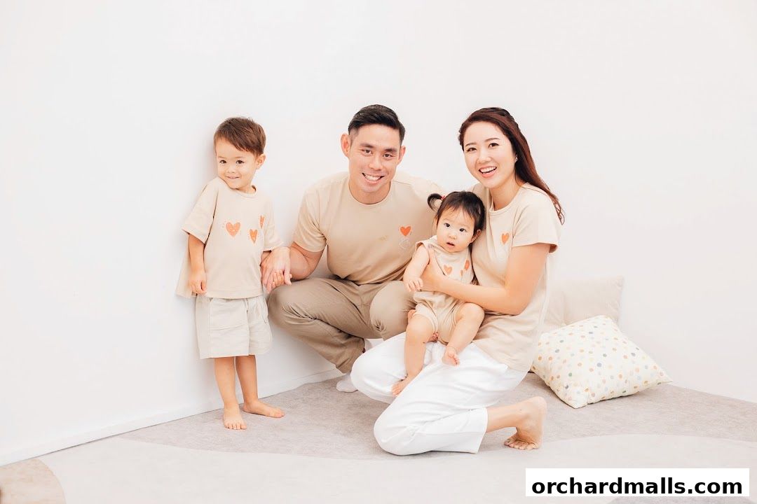 A happy family of four wearing matching outfits with heart designs.