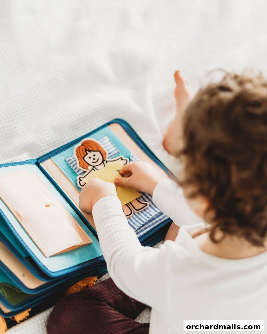 A child plays with a felt quiet book, dressing a felt doll.