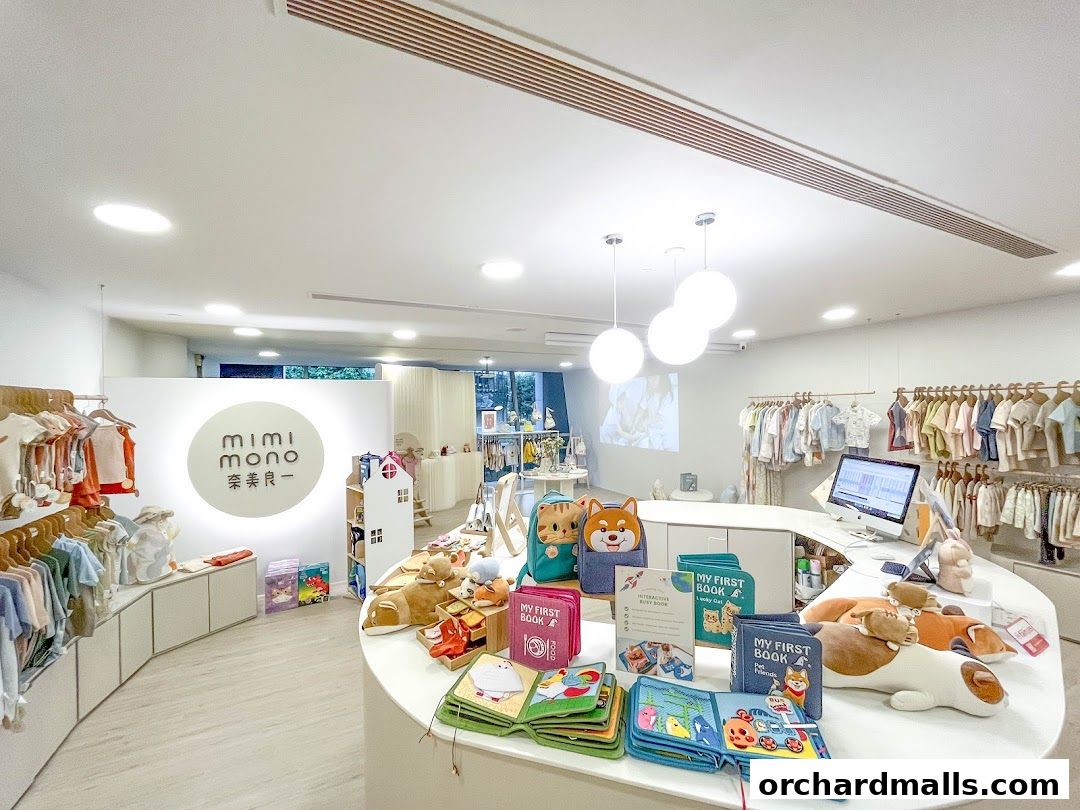 Interior view of a children's clothing and book store with displays of apparel and interactive books.