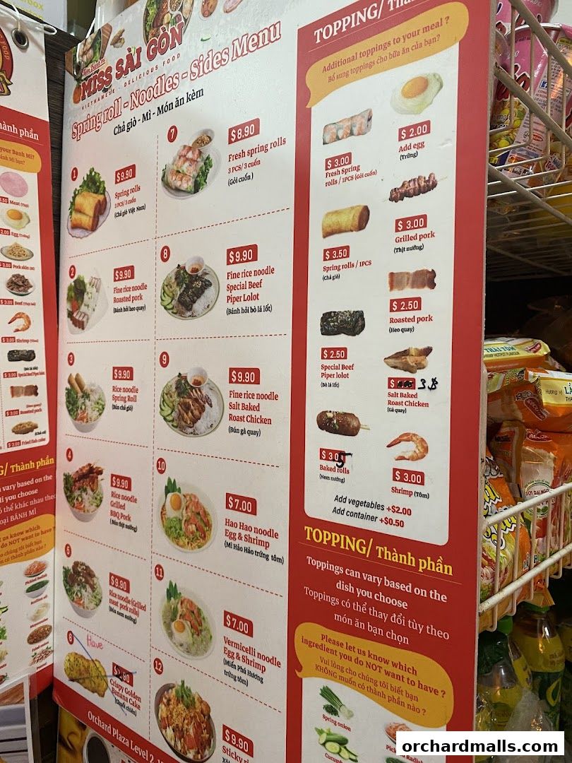 A menu board for Miss Saigon Singapore featuring Vietnamese dishes and toppings.