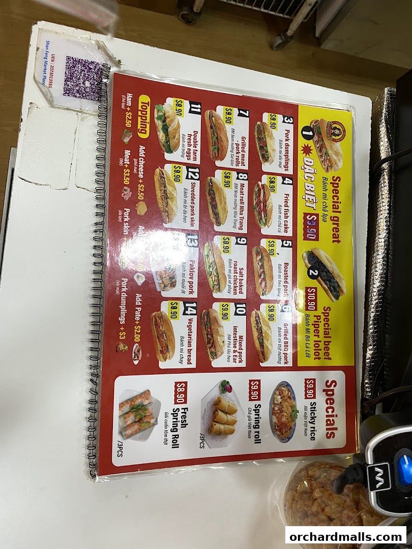A menu board displaying various Vietnamese banh mi sandwiches and spring rolls with prices.