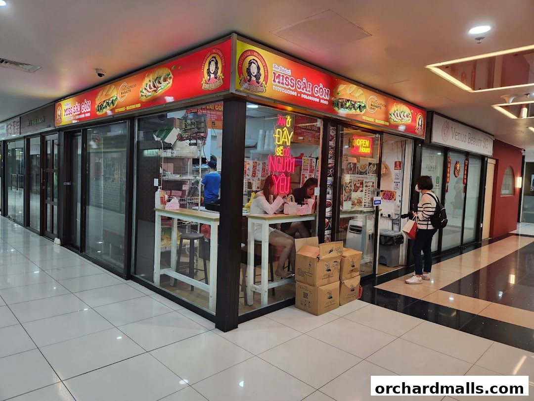 Exterior view of Miss Saigon Singapore, a Vietnamese restaurant with a prominent sign and open interior.