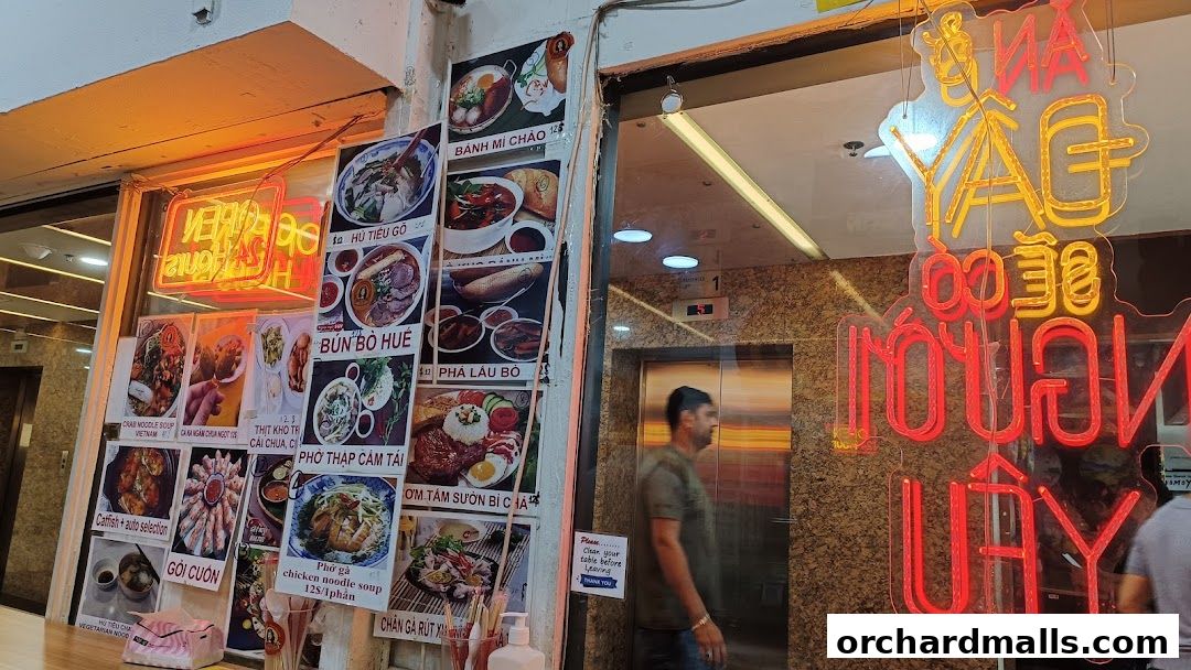 A Vietnamese restaurant shop front with food photos and neon signs.