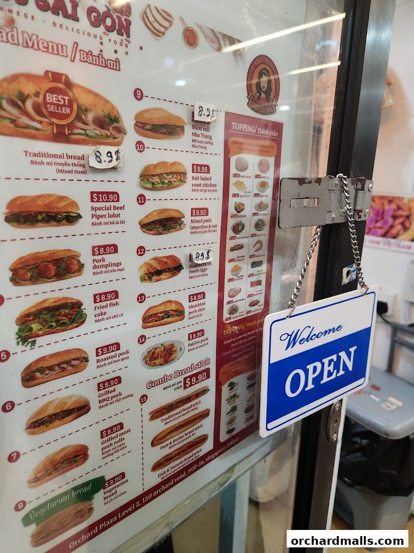 A menu board for Miss Saigon Singapore showcasing various Banh Mi options and toppings.