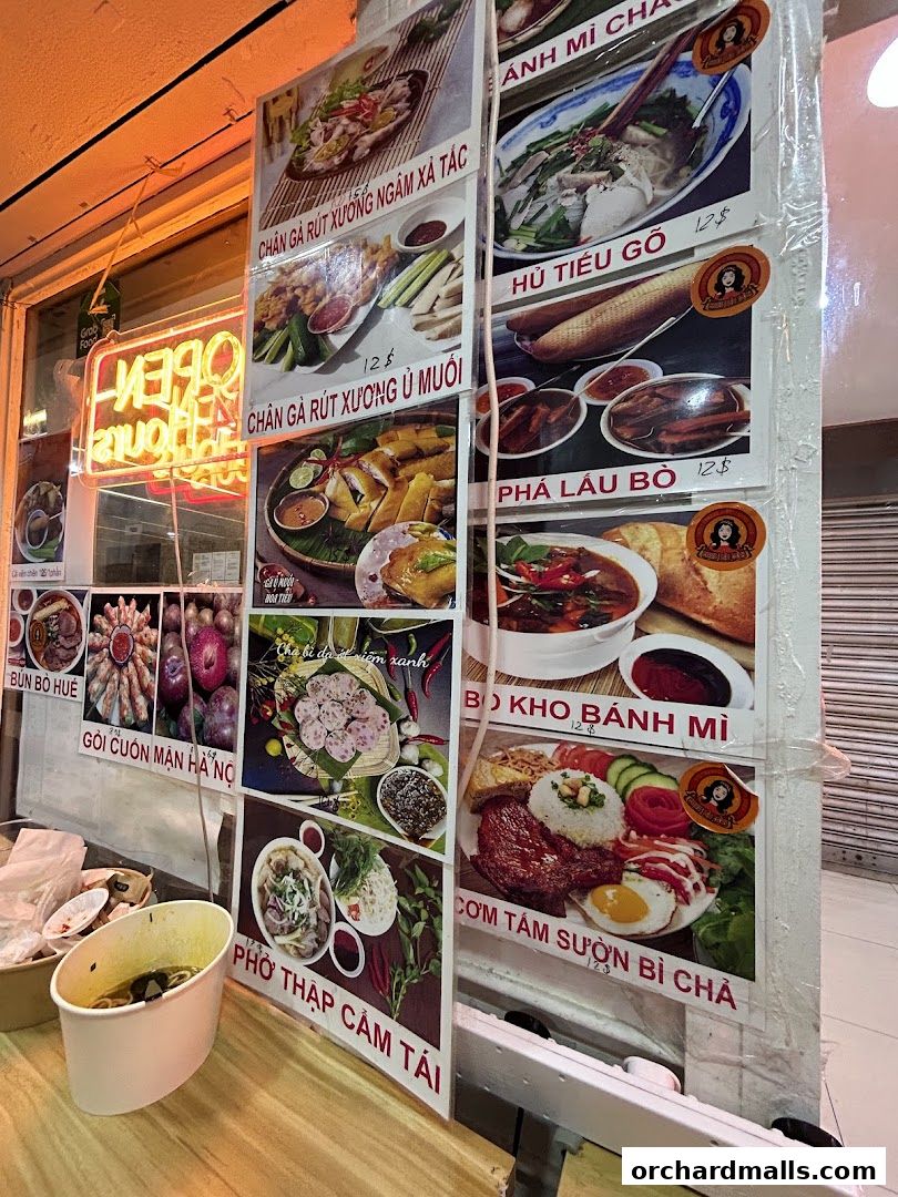 A display of Vietnamese dishes with images and prices outside a restaurant.