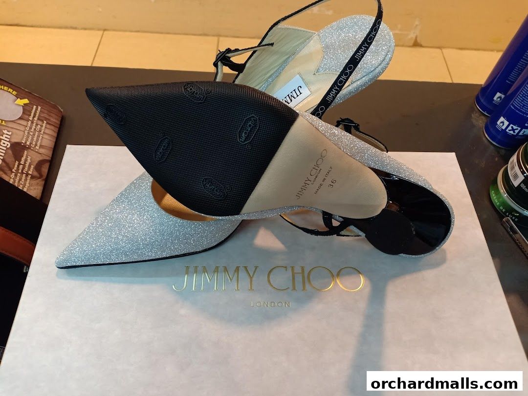 Sparkling silver Jimmy Choo heels displayed on their branded box.