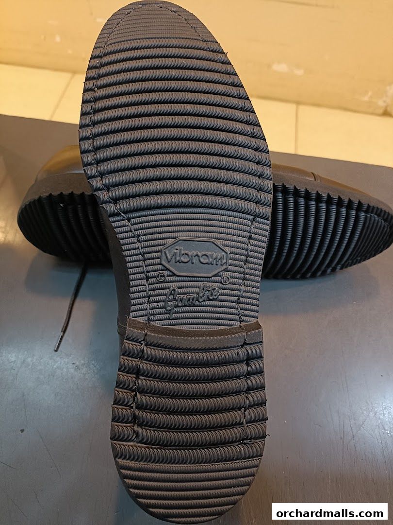 Close-up of the sole of a black shoe, featuring a Vibram sole and a Gambie logo.