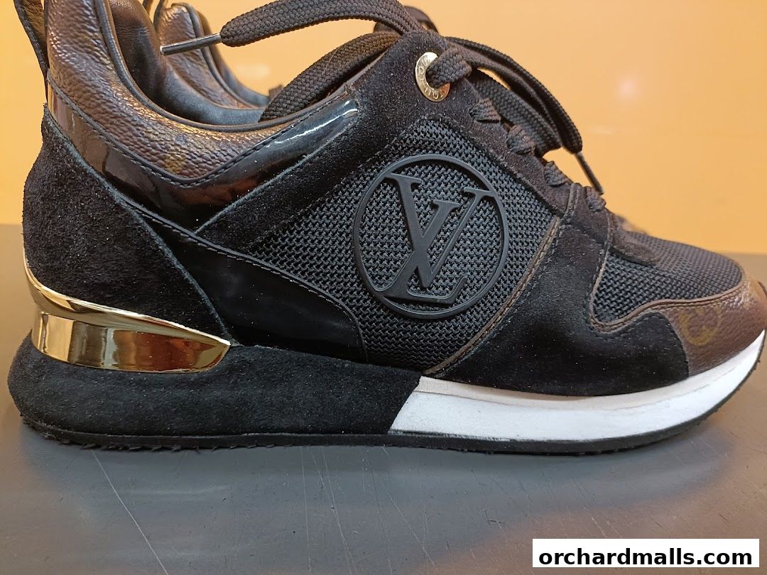 Close-up of a black Louis Vuitton sneaker with suede and patent leather accents.