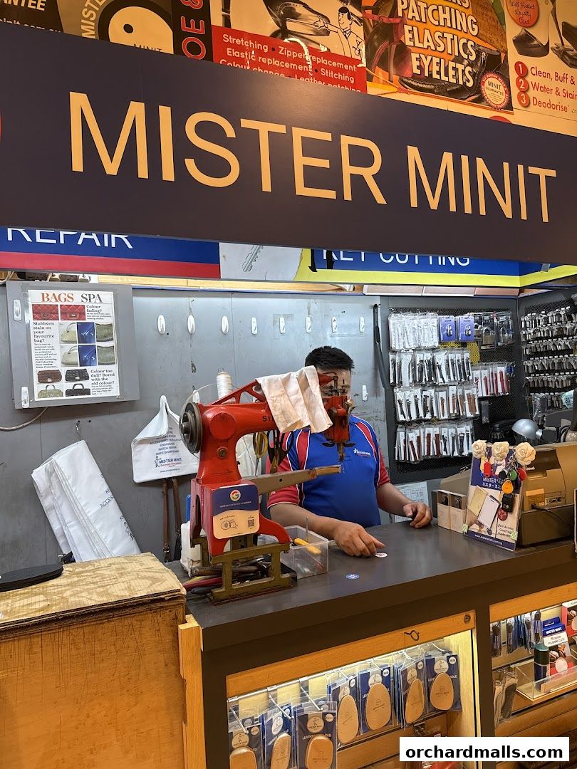 Mister Minit shop front with a worker at the counter and various repair services advertised.