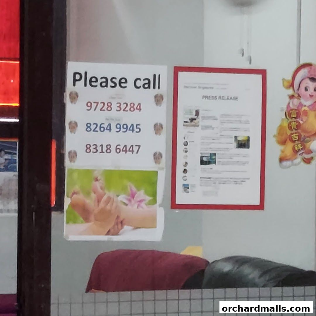 A sign with contact numbers and an image of foot reflexology at Moi Fong Foot Reflexology Center.