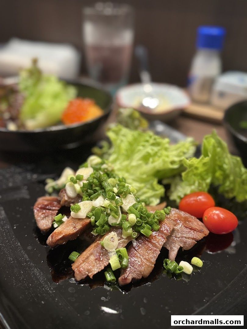 Slices of grilled meat topped with green onions and served with lettuce and cherry tomatoes.