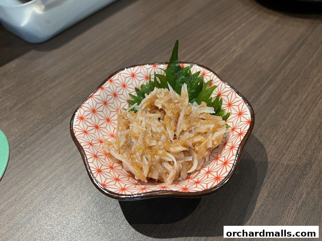 A small, decorative bowl filled with shredded food and garnished with green leaves.