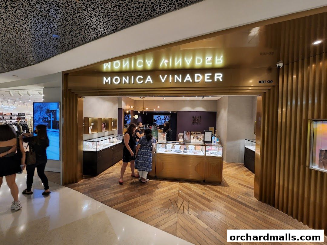 The entrance to a Monica Vinader jewelry store with illuminated signage and display cases.