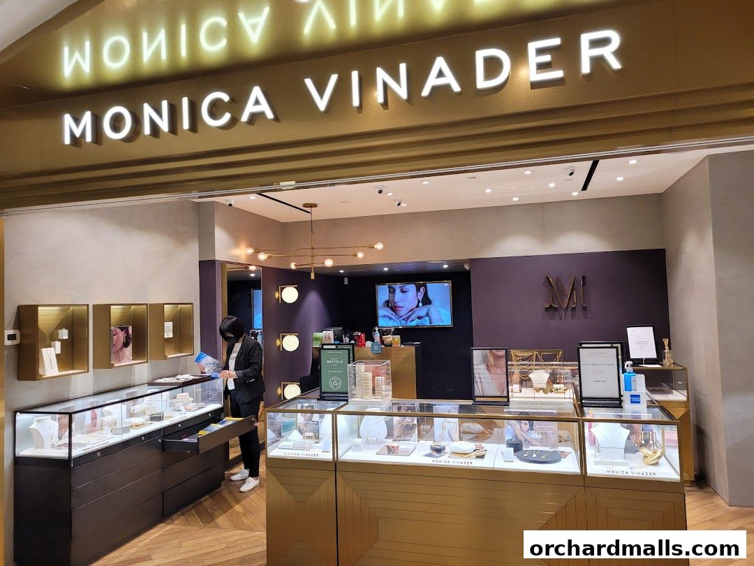 The Monica Vinader jewelry store features illuminated signage and display cases filled with necklaces and earrings.