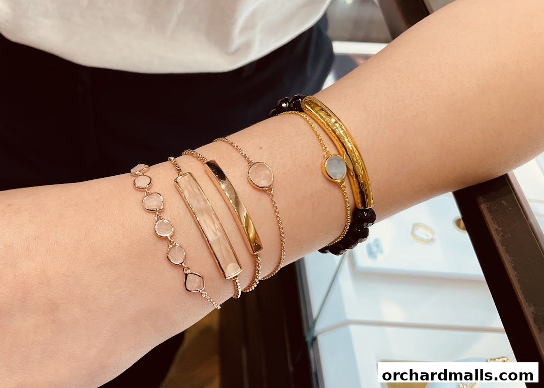 A person's arm adorned with multiple stylish bracelets from Monica Vinader.