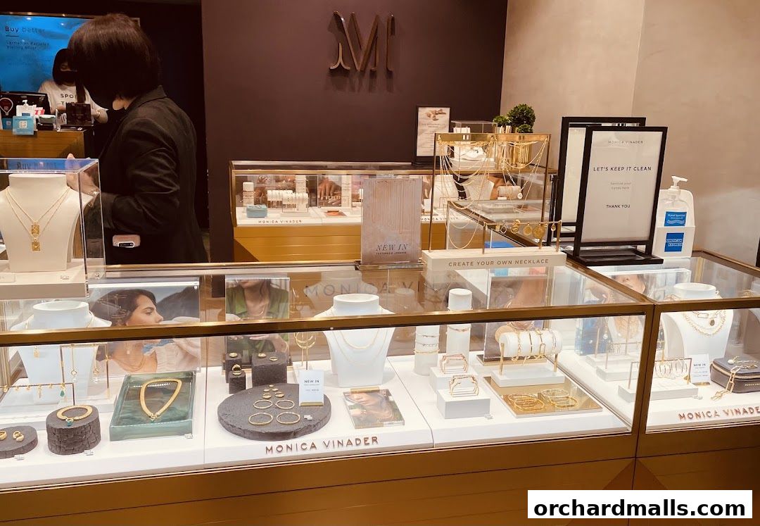 Interior view of a Monica Vinader jewelry store showcasing necklaces, bracelets, and rings in display cases.