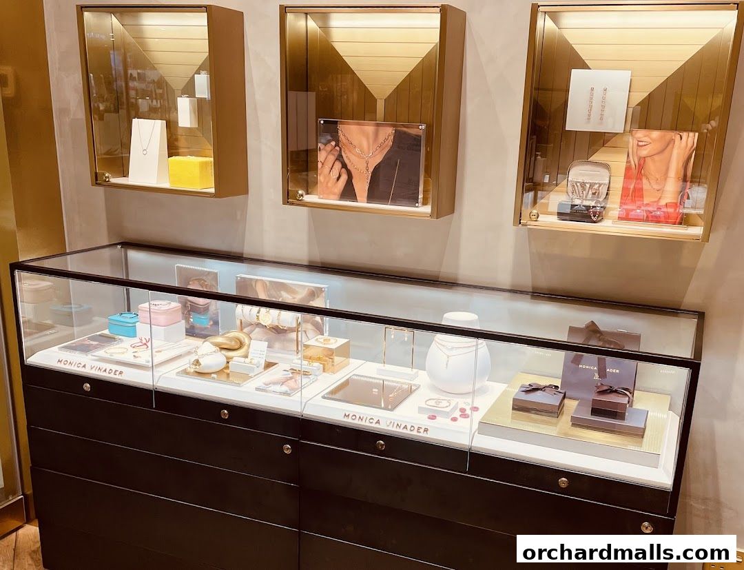 Interior shot of a Monica Vinader jewelry store displaying necklaces, bracelets, rings, and gift boxes.