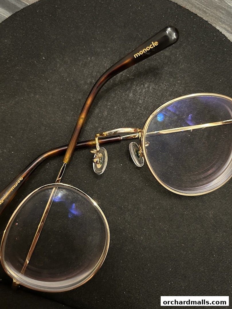 A close-up shot of stylish eyeglasses with the 'monocle' logo visible on the arm.