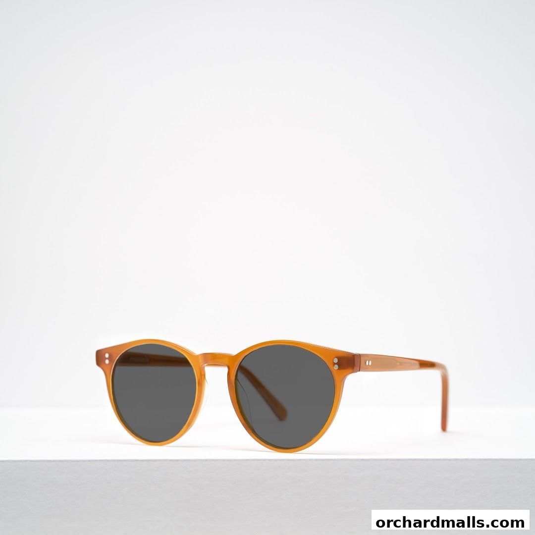 A pair of stylish, amber-colored sunglasses with dark lenses is displayed.