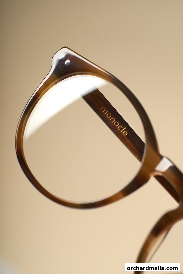 Close-up of stylish tortoiseshell eyeglasses with the 'monocle' logo on the arm.