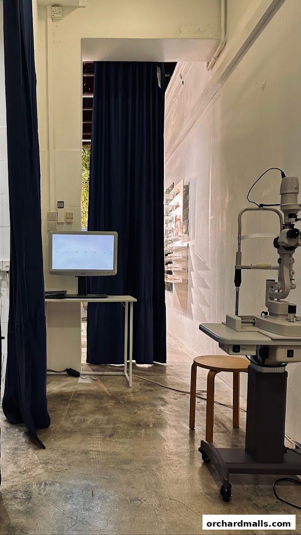 Interior of an optometry clinic with an eye examination machine and display.